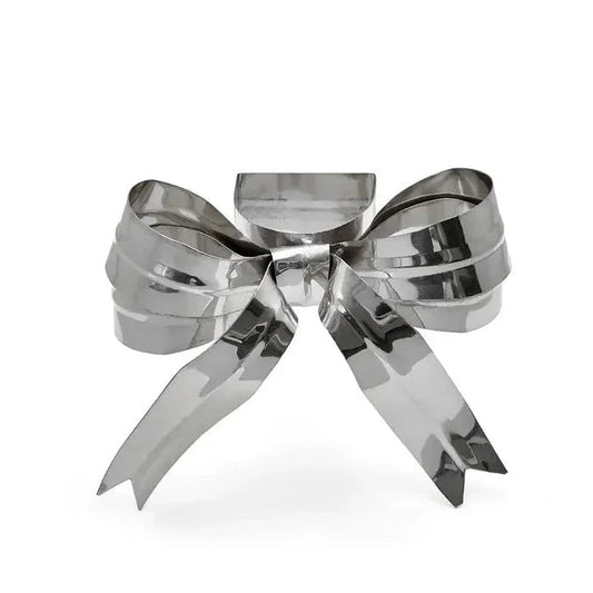 A shiny metallic silver bow-shaped decorative object, photographed on a clean white background.