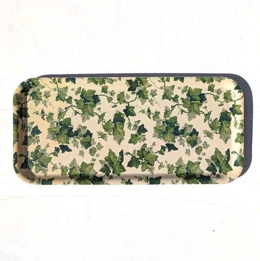 A rectangular metal tray with rounded corners, featuring an all-over green ivy leaf pattern on a cream-colored background, with a dark metallic rim.