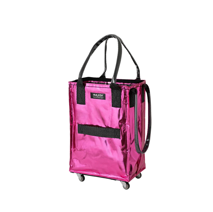A metallic pink rolling utility tote bag with black handles, a black front mesh pocket, and small caster wheels, shown on a plain white background.