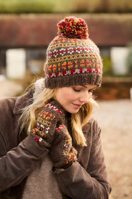 Person wearing a colorful knitted hat and mittens outdoors