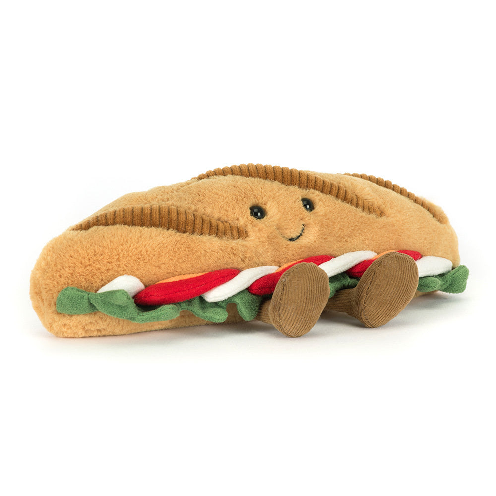 Plush toy shaped like a Baguette with a smiling face on a white background