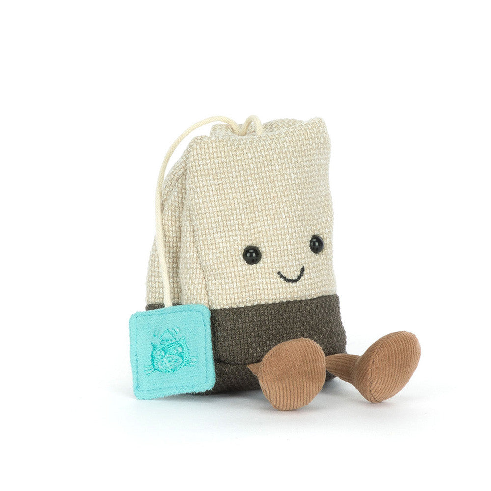 Toy with a drawstring tea bag and a small square block on a white background