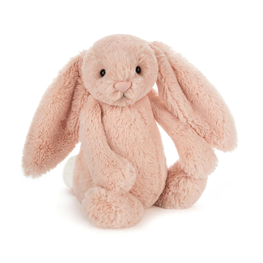 A plush stuffed bunny in a soft blush pink color, sitting upright against a clean white background.