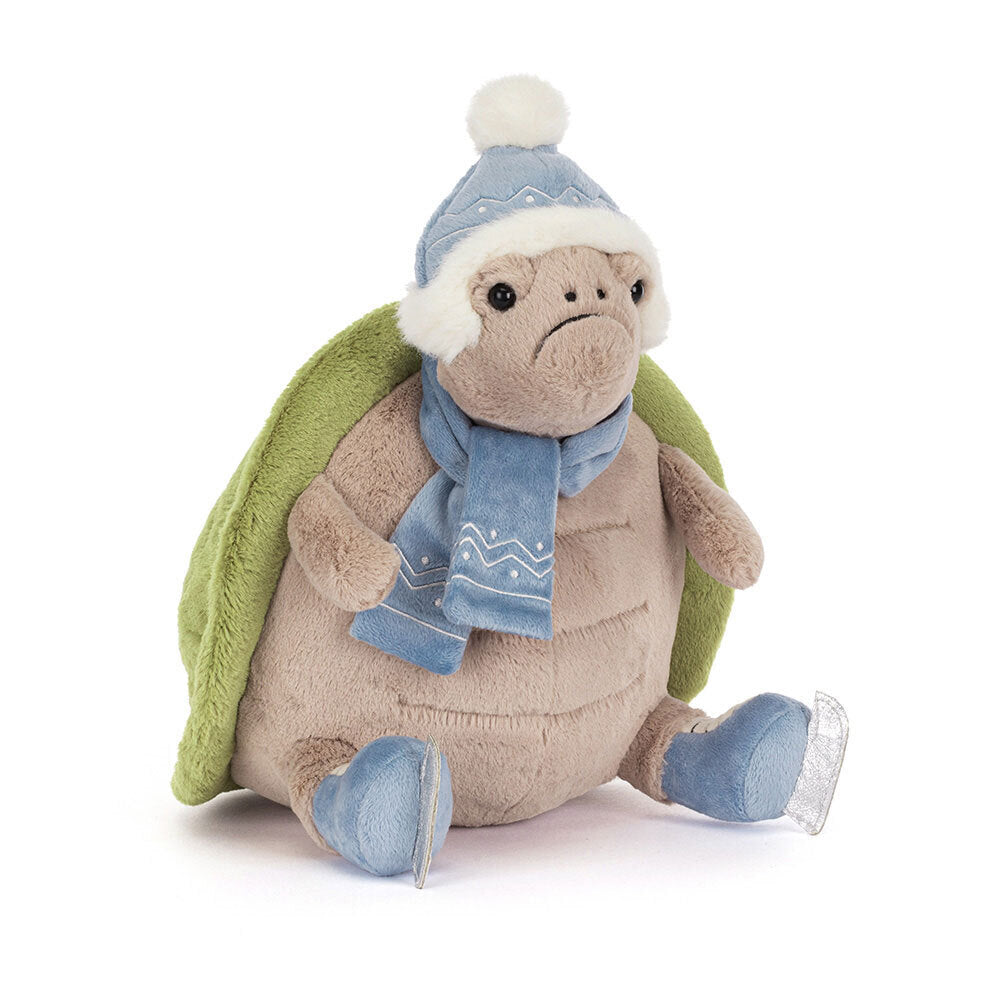 Plush turtle toy wearing a blue hat, scarf, and shoes on a white background