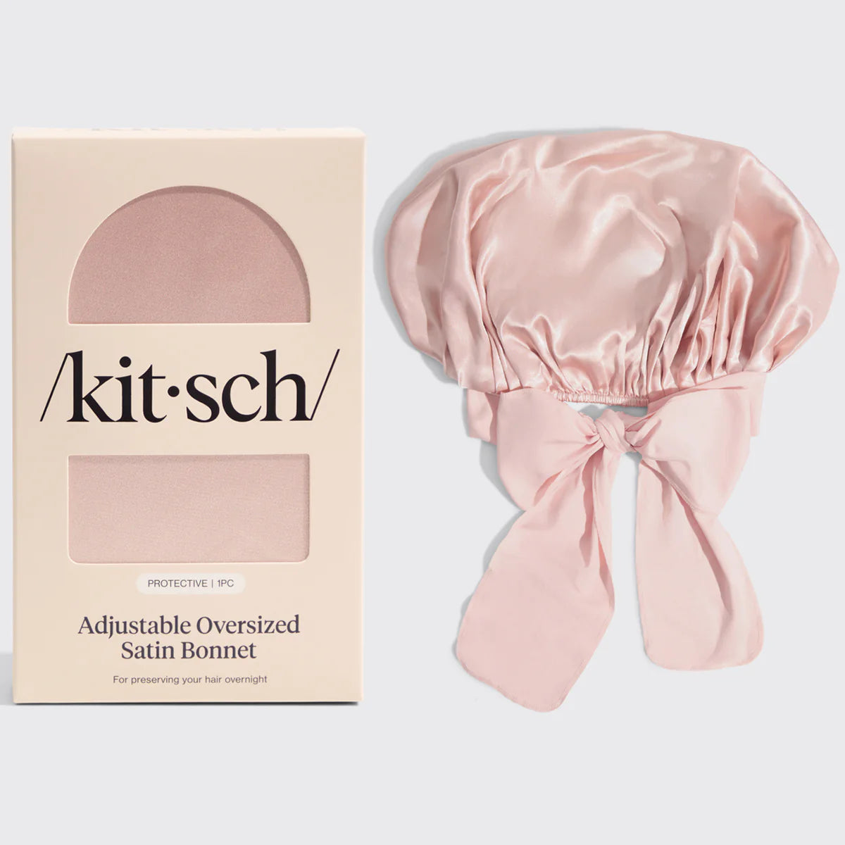 Pink satin bonnet with 'kitsch' brand packaging on a light gray background