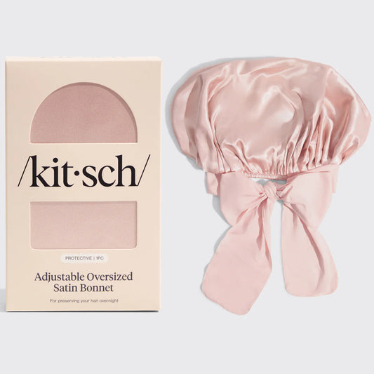 Pink satin bonnet with 'kitsch' brand packaging on a light gray background