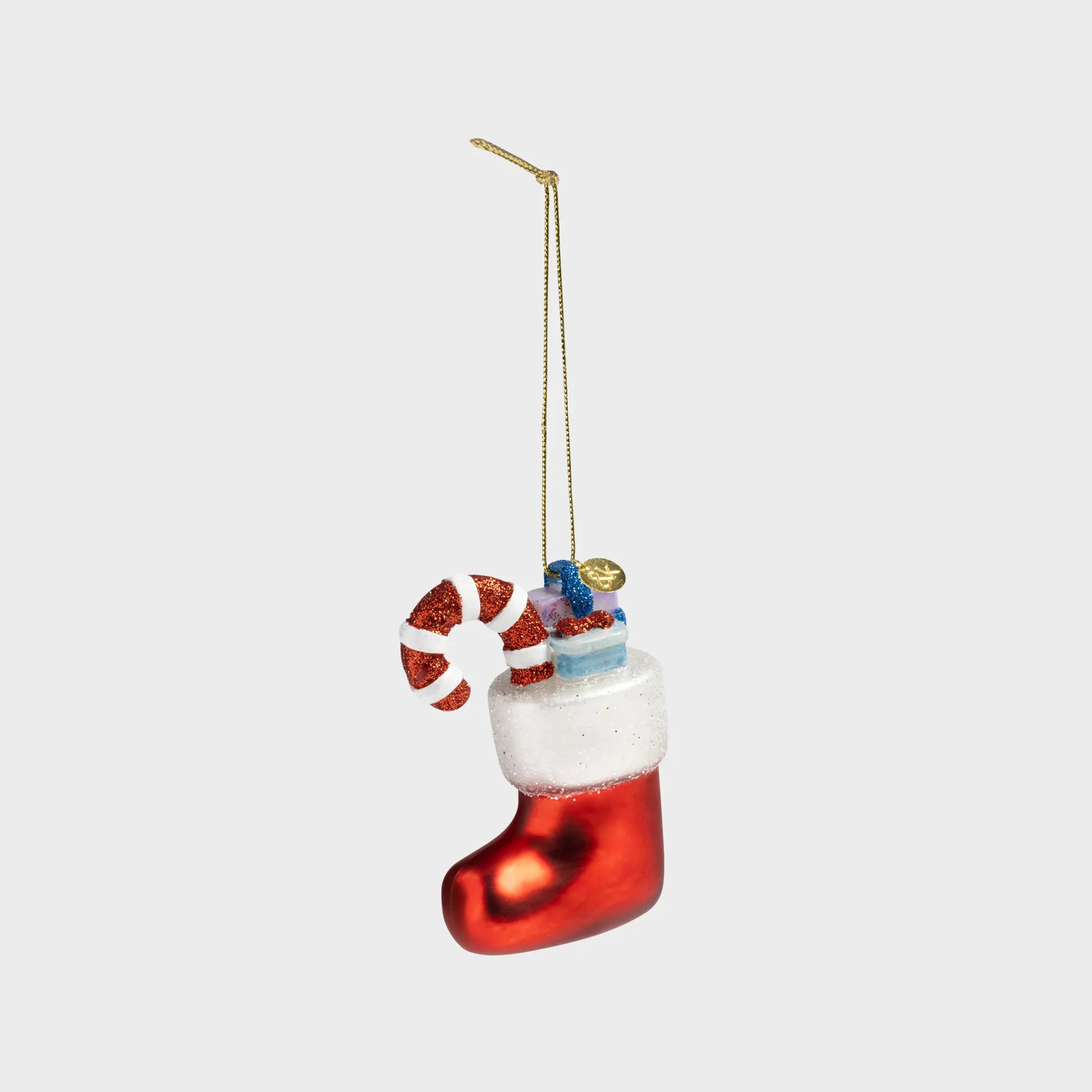 Christmas ornament shaped like a red stocking with candy cane and presents on a white background
