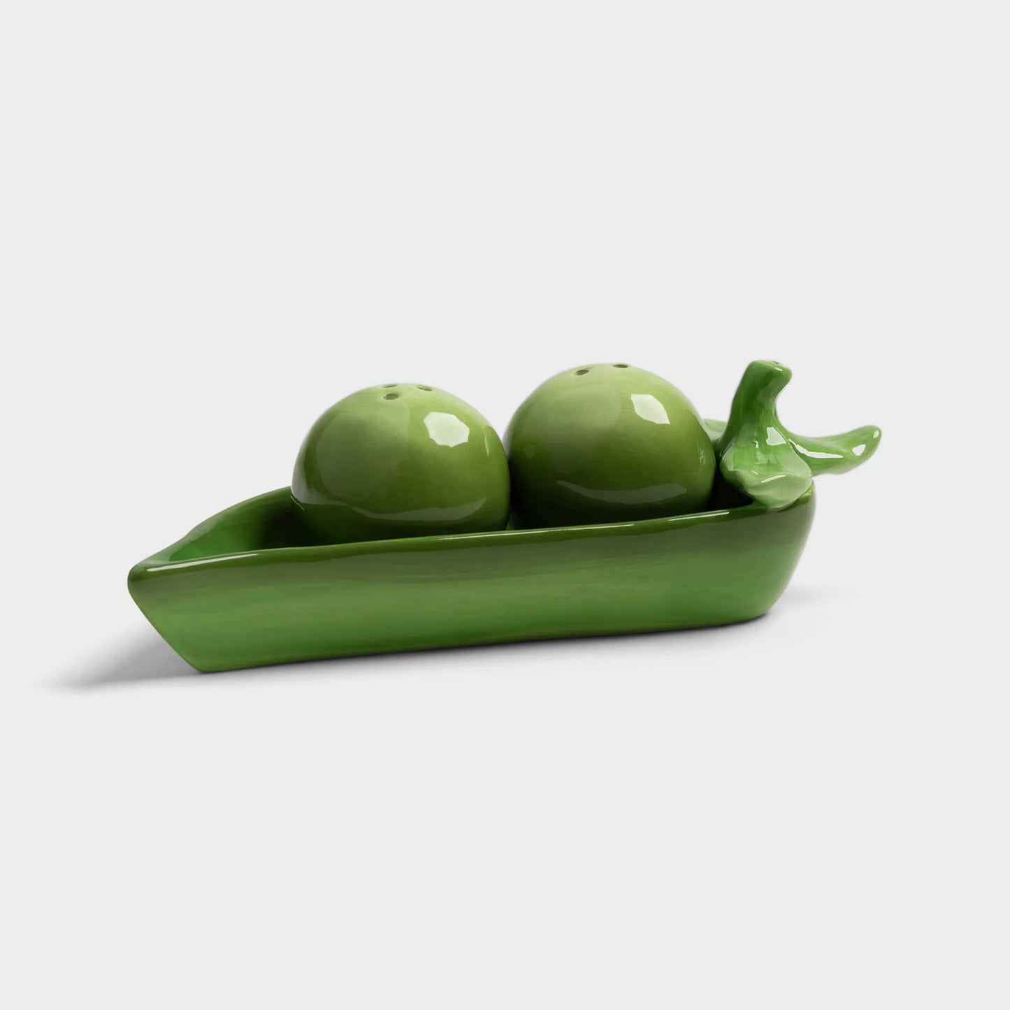 Green ceramic set with two spheres and a boat-shaped container on a white background