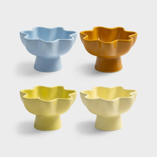 Four ceramic bowls in blue, orange, yellow, and beige on a light gray background