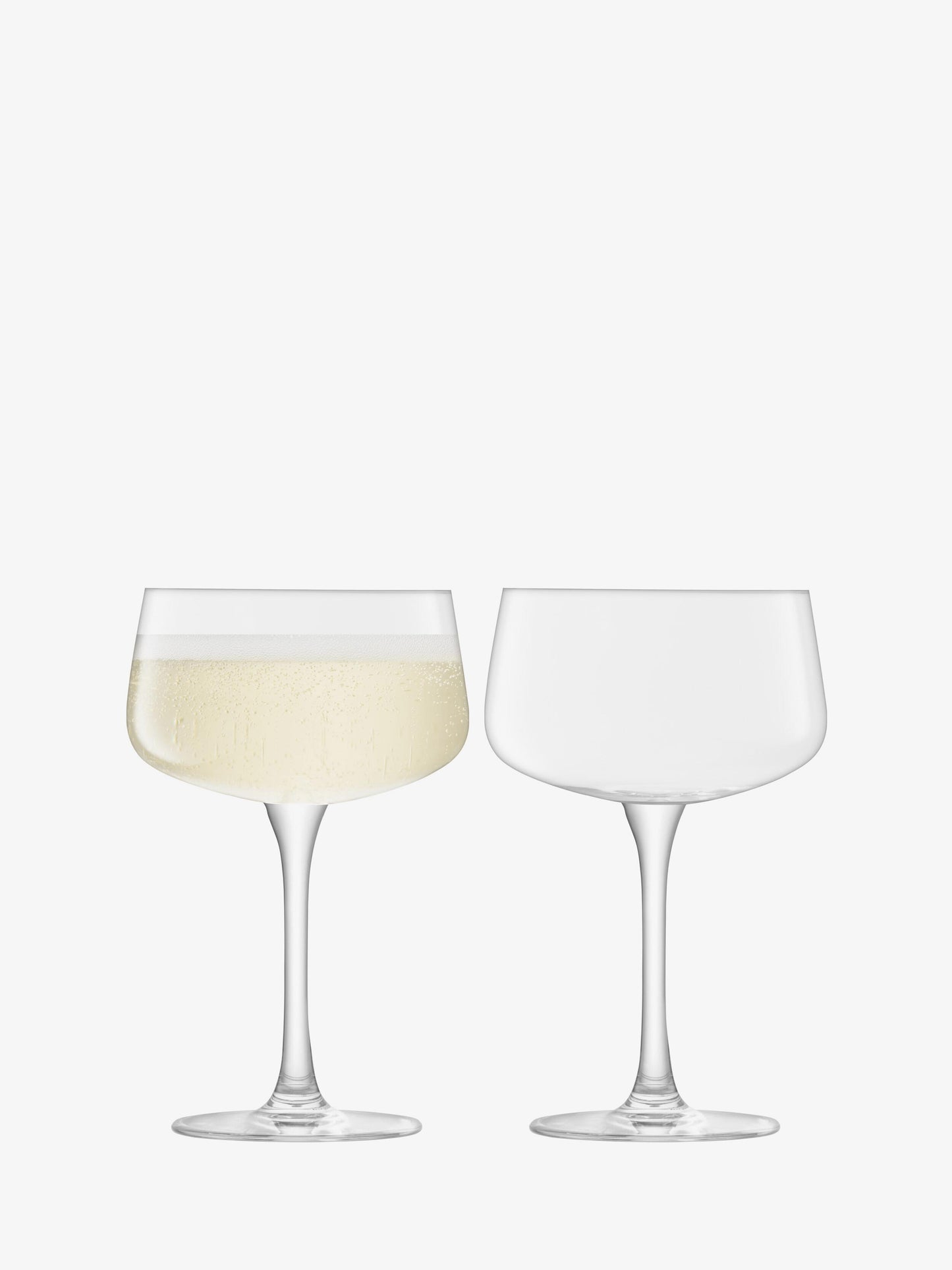 Two wine glasses, one filled with white wine, on a white background