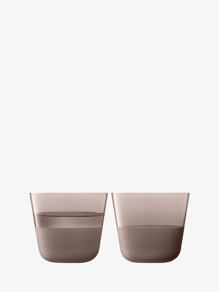Two brown glasses filled with water on a white background