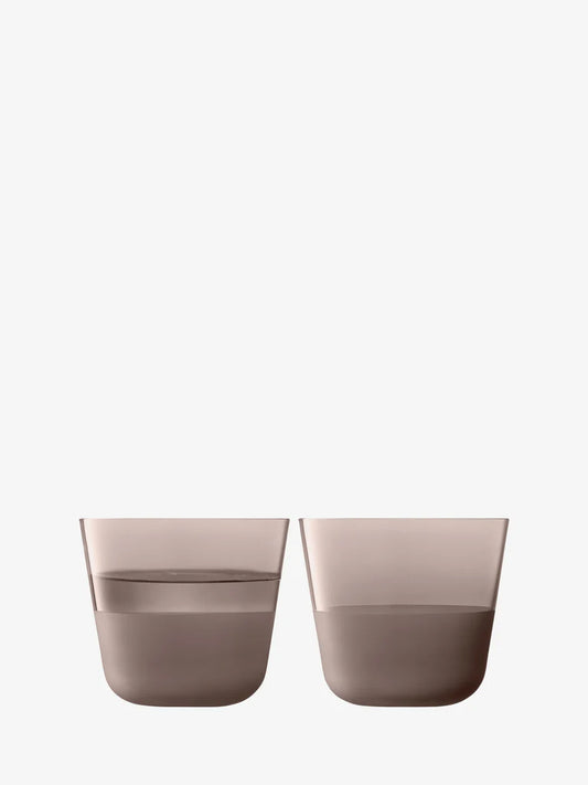 Two brown glasses filled with water on a white background