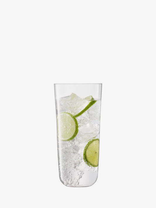 Clear glass filled with ice and lime wedges on a white background
