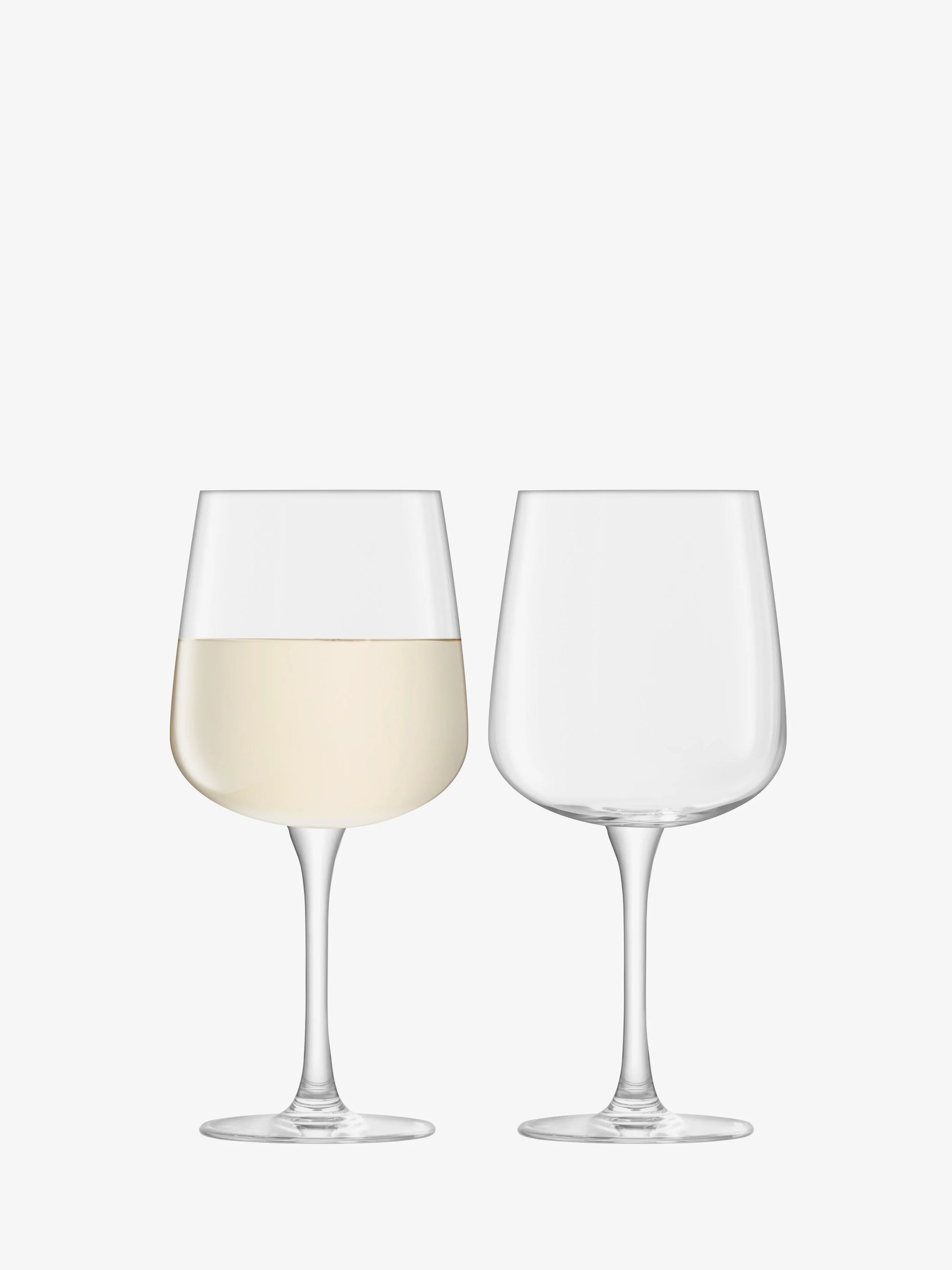 Two wine glasses, one filled with white wine, on a white background