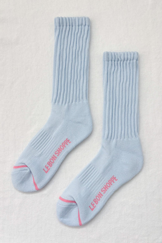 Pair of light blue socks with red text on a beige background
