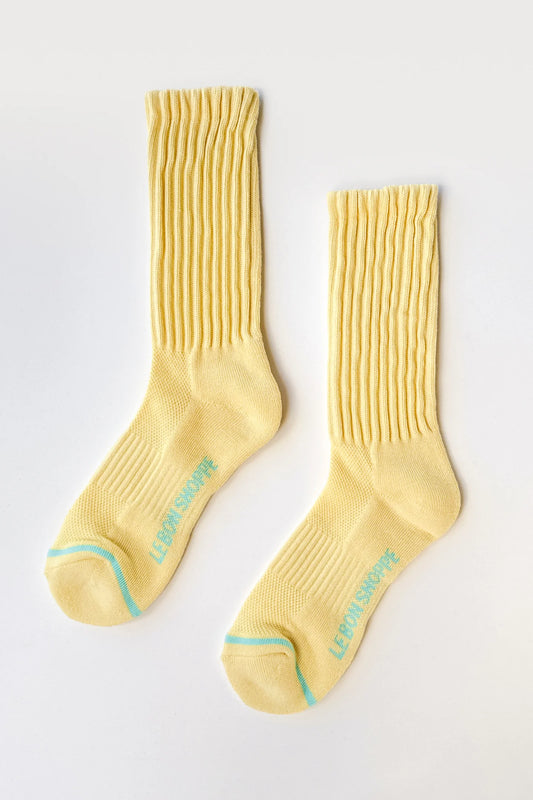 Pair of yellow socks with a brand logo on a light gray background