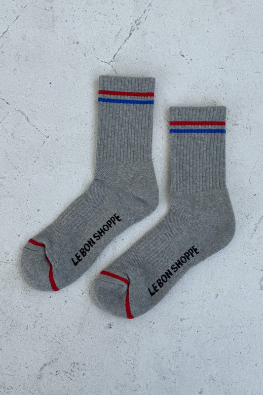 Gray socks with red and blue accents and 'LEBON SHOPPE' branding on a light gray background