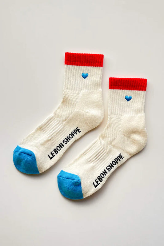 Pair of socks with red tops and blue toes and heels on a light gray background
