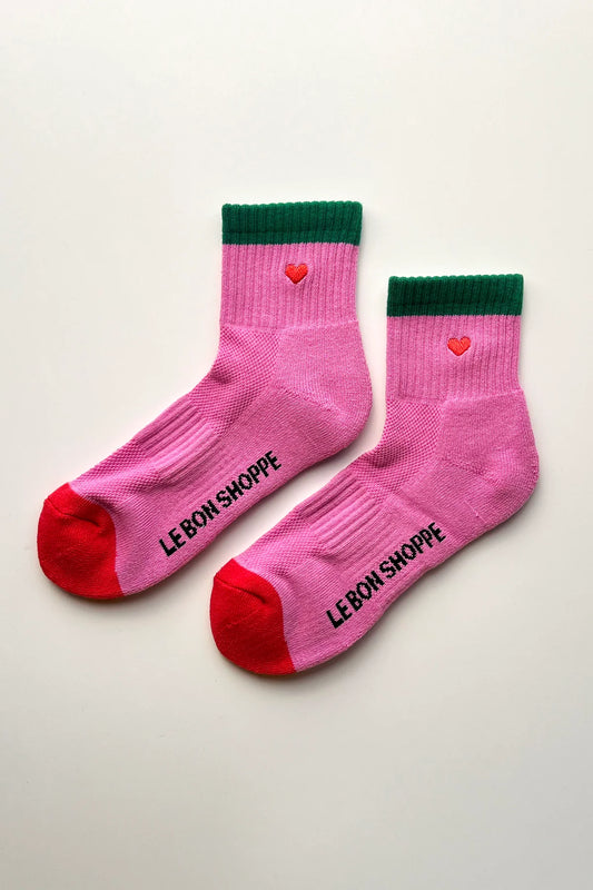 Pink socks with green crowns and red toes on a light gray background