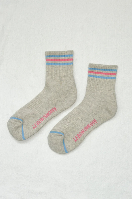 Gray socks with colorful stripes and 'Le Bon Shoppe' branding on a light gray background
