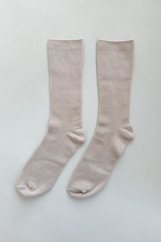 Pair of beige socks on a light gray background