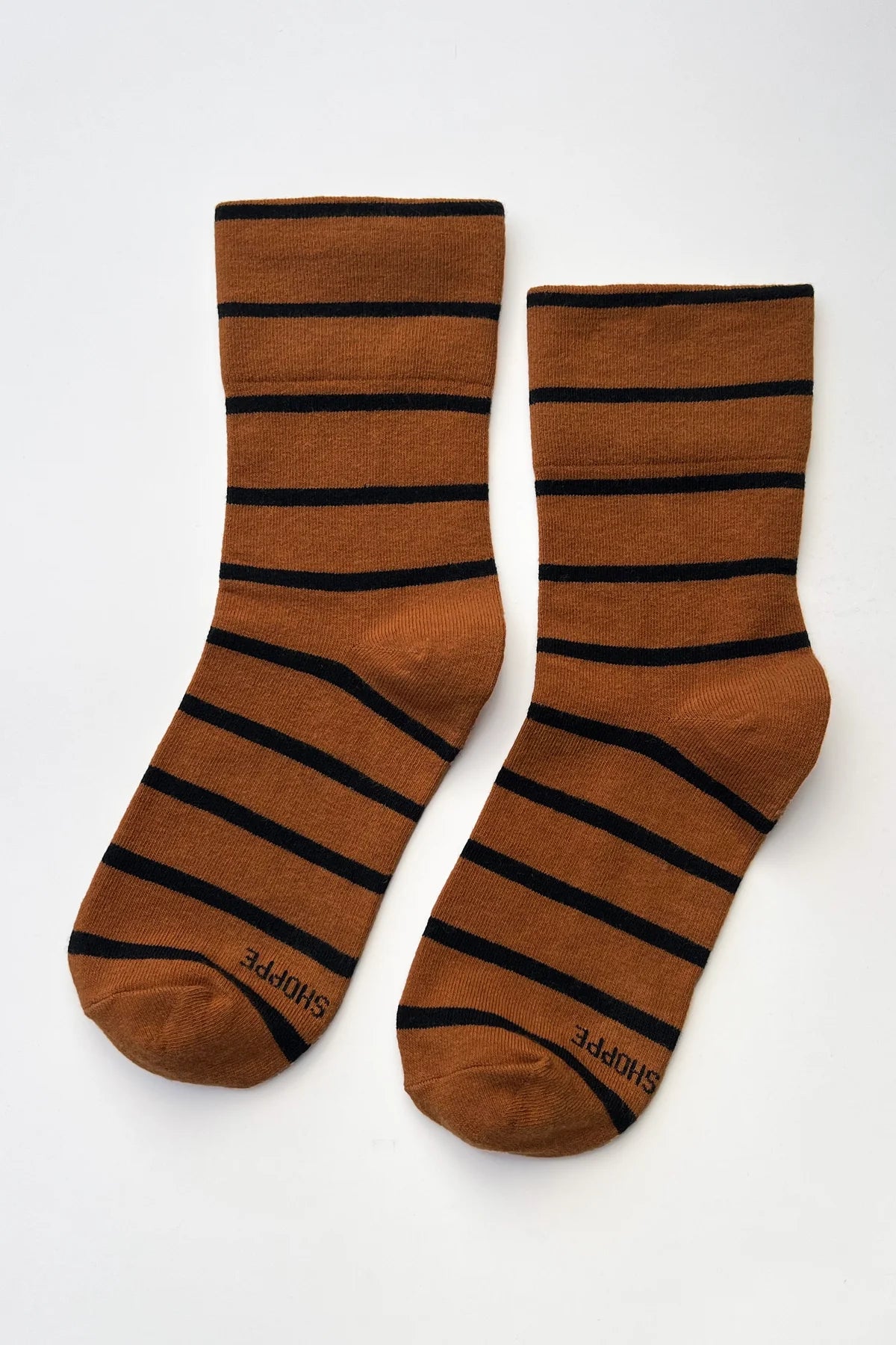 Pair of brown socks with black stripes on a white background