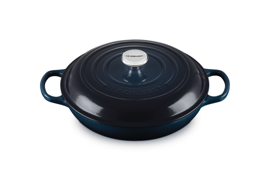 Blue enameled cast iron casserole dish with a lid on a white background