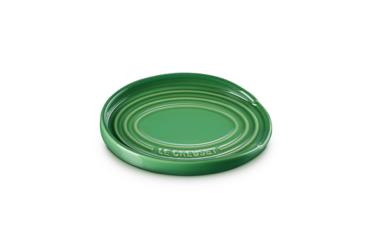 Green ceramic spoon rest plate on a white background