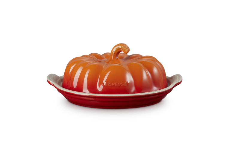 Orange ceramic butter dish shaped like a pumpkin on a white background