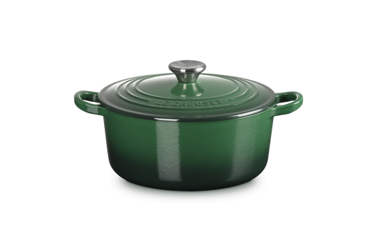 Green enameled cast iron Dutch oven on a white background