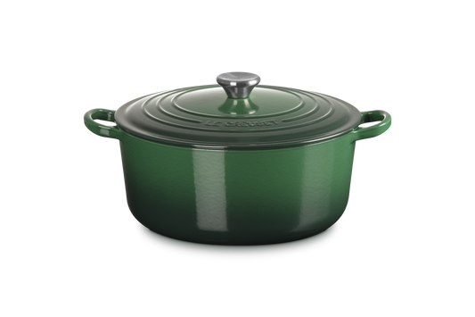 Green enameled cast iron Dutch oven with lid on a white background