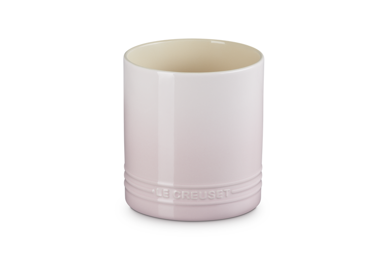 Pink ceramic cup with 'Le Creuset' branding on a white background