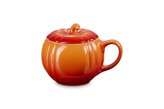 Orange ceramic mug shaped like a pumpkin on a white background