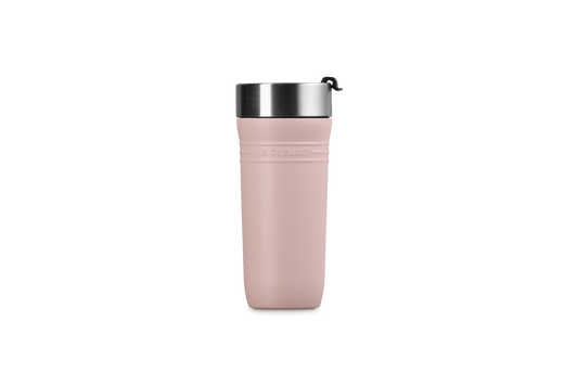 Pink travel mug with a black lid on a white background