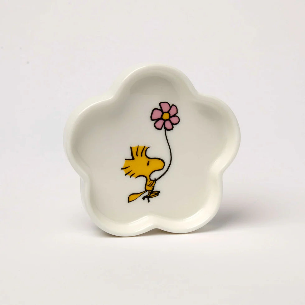 White ceramic dish with a cartoon character holding a pink flower on a white background