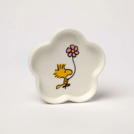 White ceramic dish with a cartoon character holding a pink flower on a white background