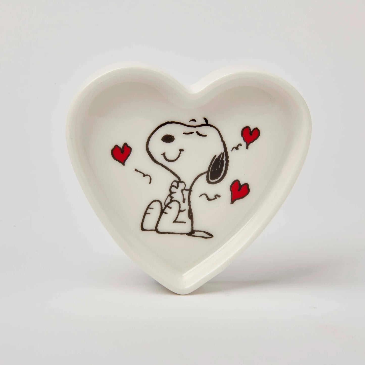 Heart-shaped ceramic dish with a cartoon character holding hands with a heart design on a white background