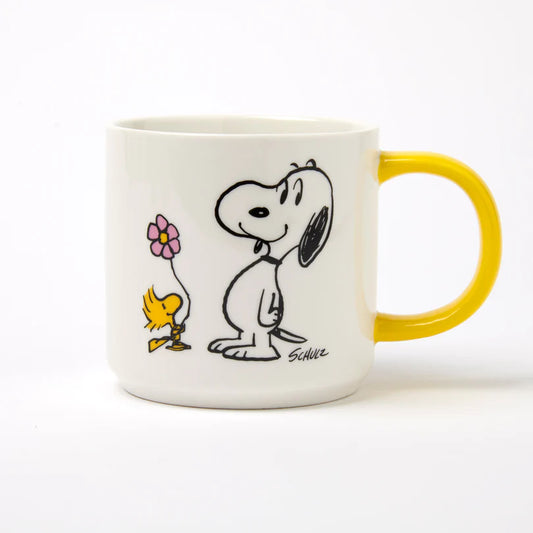 White mug with yellow handle featuring cartoon characters on a white background