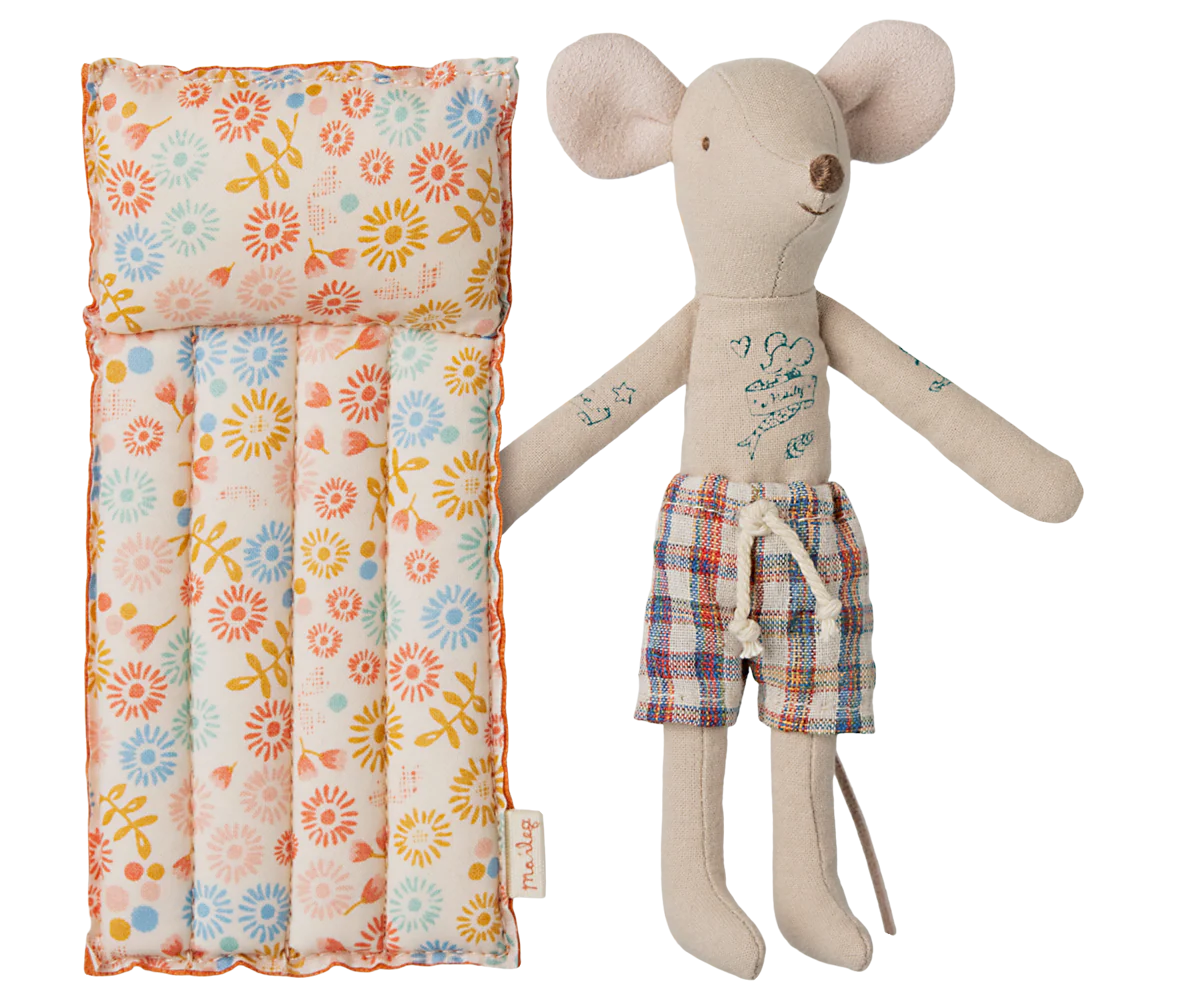 Stuffed mouse toy with plaid shorts next to a Air Mattress on a white background