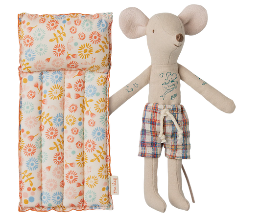 Stuffed mouse toy with plaid shorts next to a Air Mattress on a white background