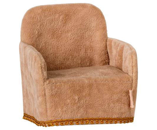 Brown plush armchair with decorative trim on a white background