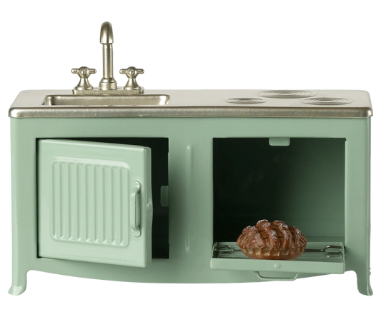 Miniature green kitchen stove with sink and oven on a white background