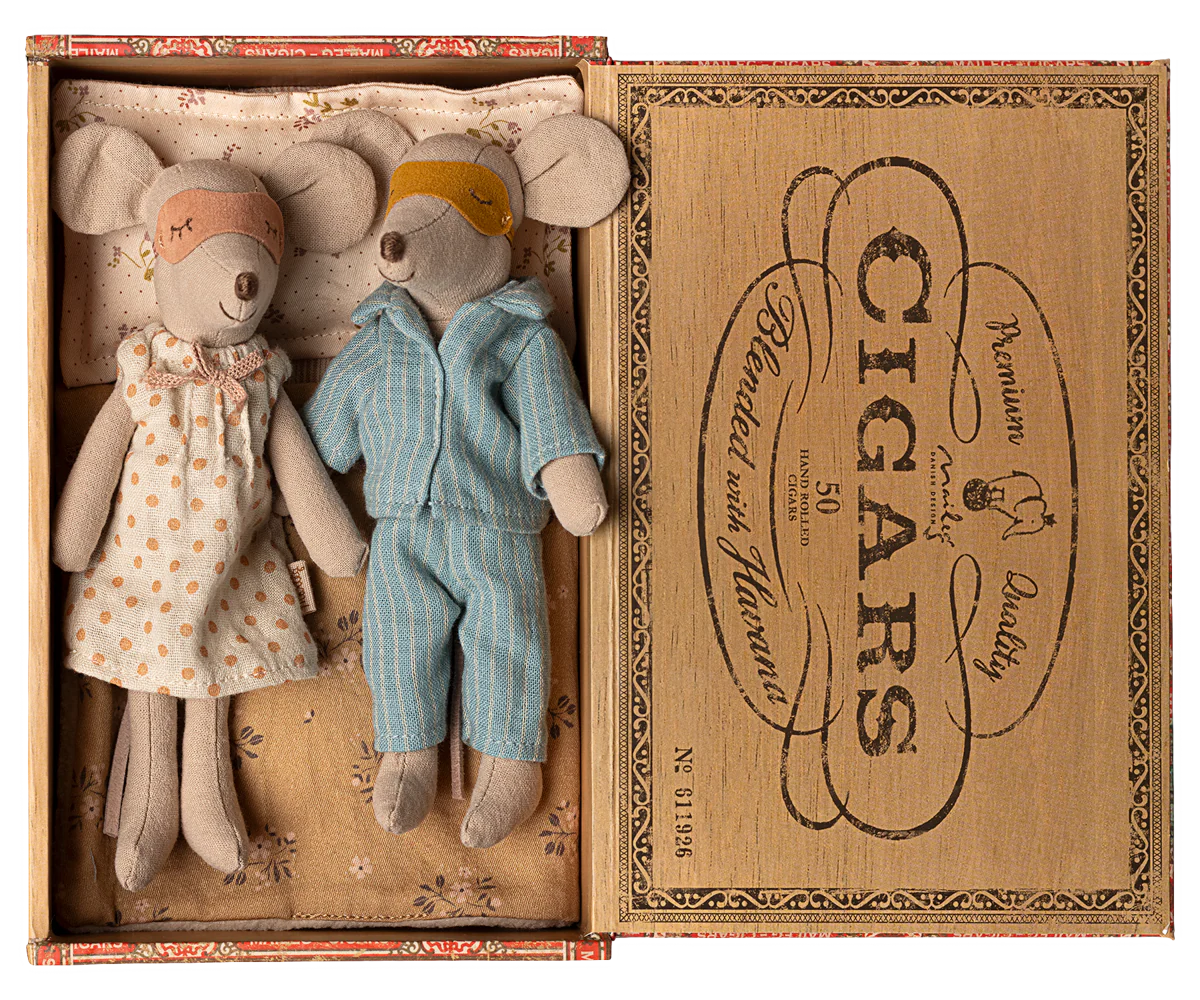Two toy mice, a girl in a dress and a boy in overalls, inside an open cigar box with decorative text.