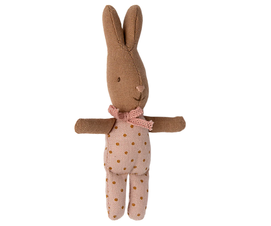 Stuffed rabbit toy with a pink bow and polka dot dress on a white background