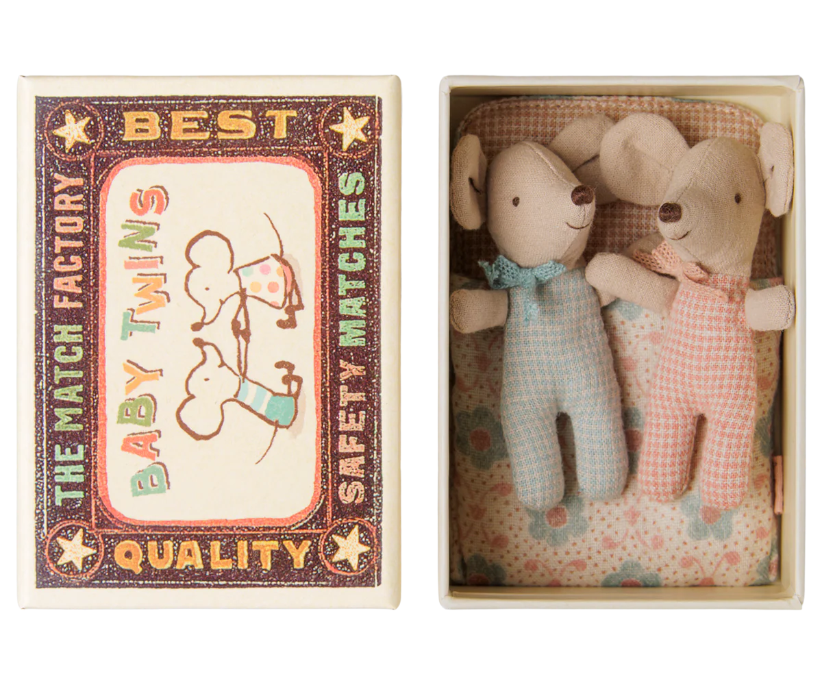 A matchbox-style gift set shown open, with the illustrated outer matchbox lid on the left and two small plush mouse toys inside the box on the right. The toys are dressed in pale blue and pale pink gingham outfits with small bows, set against a floral lining.