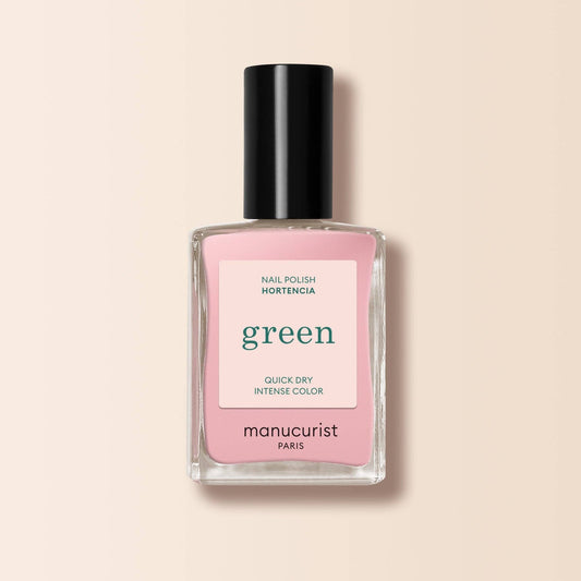 Pink nail polish bottle with black cap on a beige background