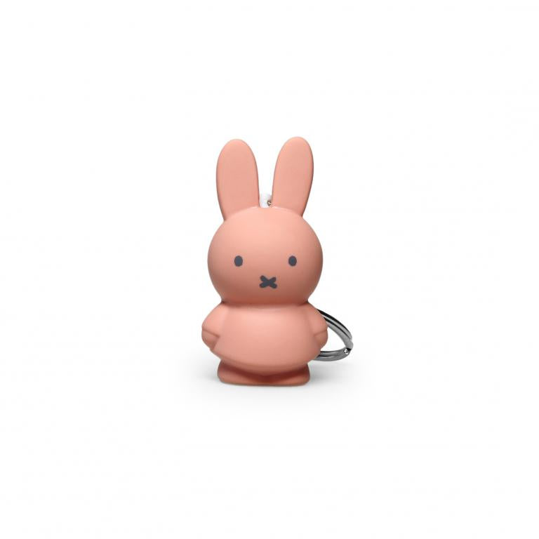 Pink bunny-shaped keychain on a white background