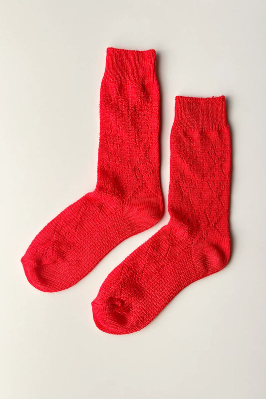 Pair of red socks on a light gray background