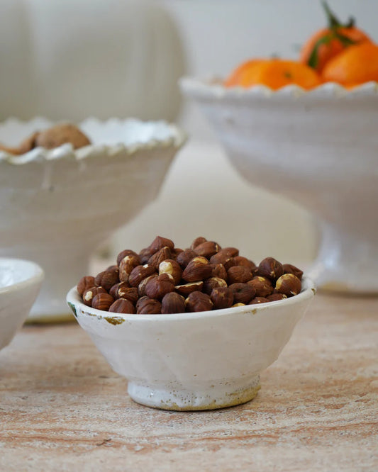 White cermic rustic glazed bowl on a beige/white background 