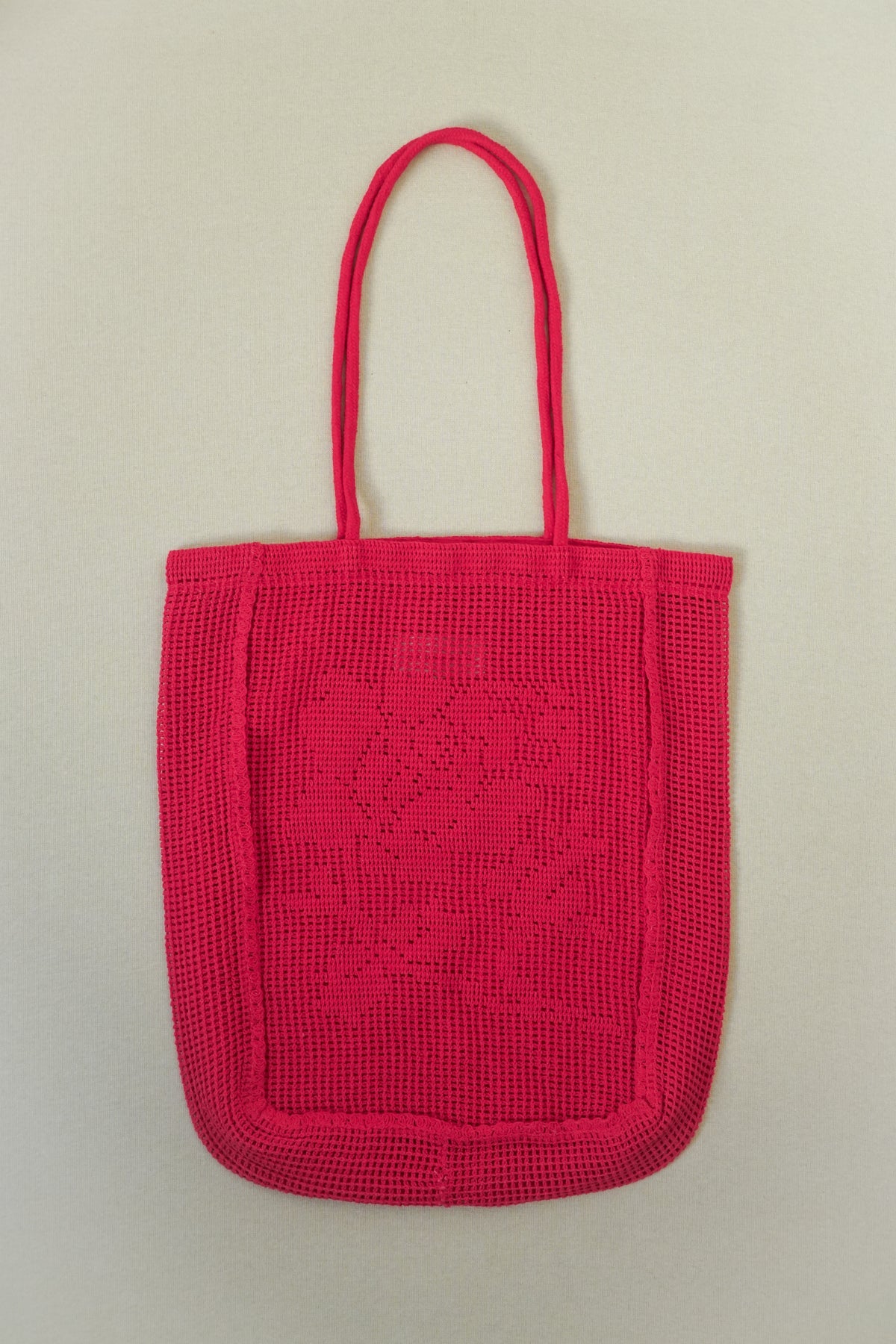 Red woven handbag on a beige background